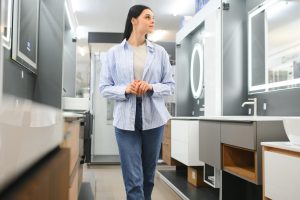 Woman chooses a mirror at home in a store.